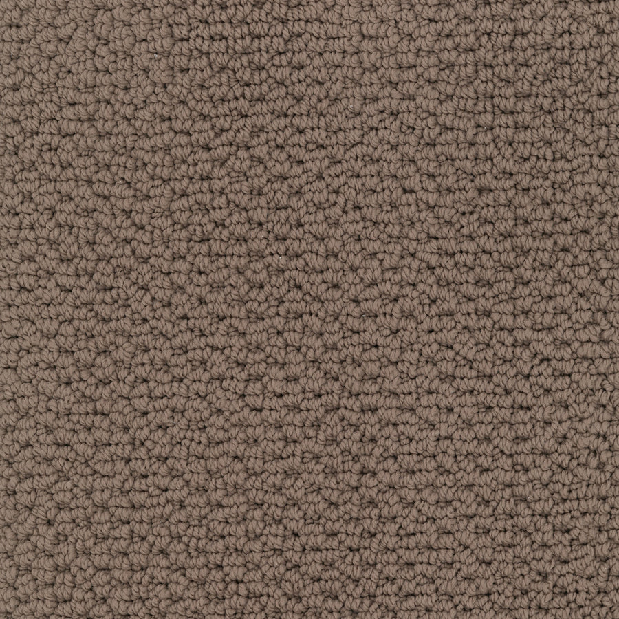 Close-up of Beachfront Berber Carpet reveals tightly woven, small loop-pile texture made from EnVision nylon in neutral tones, creating a uniform and soft surface.