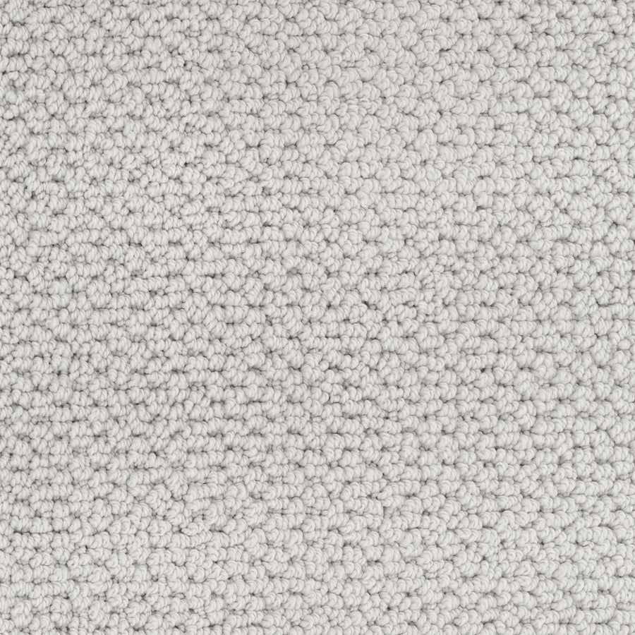 Close-up of Beachfront Berber Carpet, a light gray, textured loop-pile made with dense EnVision nylon fibers. Its tightly woven loops create a soft, even surface in neutral tones with subtle shading to enhance its quality.