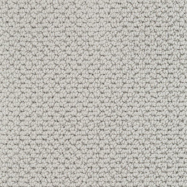 Close-up view of Beachfront Berber Carpet in light gray. This looped-pile performance carpet features small, uniform loops and a pebble-like, textured surface in neutral natural tones for a soft, even pattern.