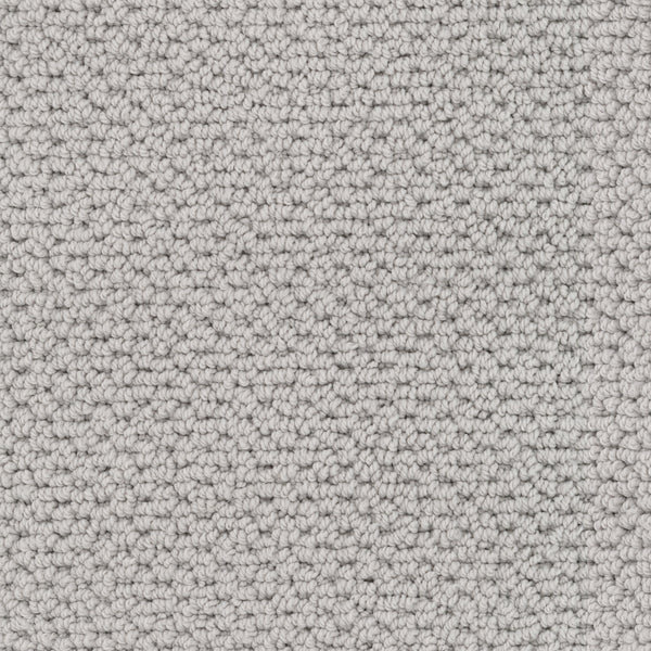 Close-up view of Beachfront Berber Carpet, a textured light gray performance carpet made from EnVision nylon with tightly woven loops for a uniform, slightly raised surface in neutral natural tones.