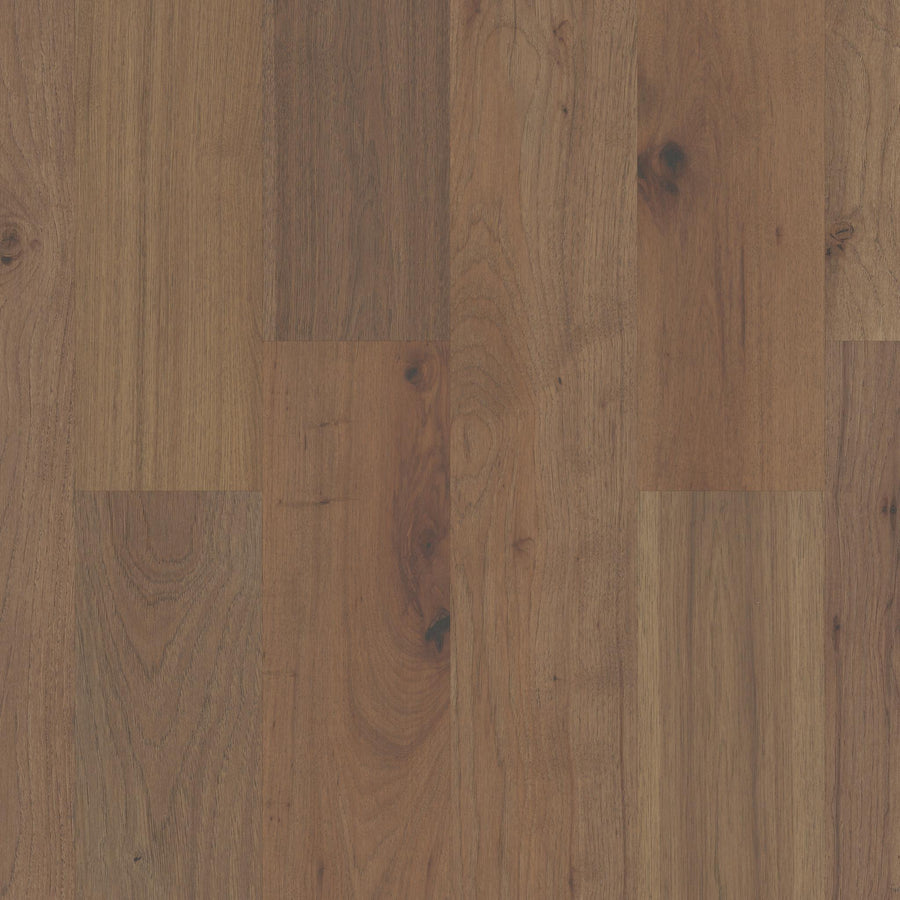 Close-up view of Biltmore Hickory & White Oak 7 1/2" Hardwood flooring featuring natural grain, knots, and brown shades in a low-gloss finish, highlighting the beauty of this heirloom-quality floor.