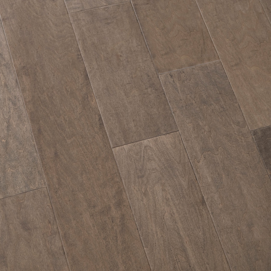 Close-up of Farmhouse Chic 6 1/2" Handscraped Maple Hardwood flooring shows rich brown planks with natural grain, slight color variations, and a matte finish that highlights the staggered pattern for a refined Farmhouse Chic look.