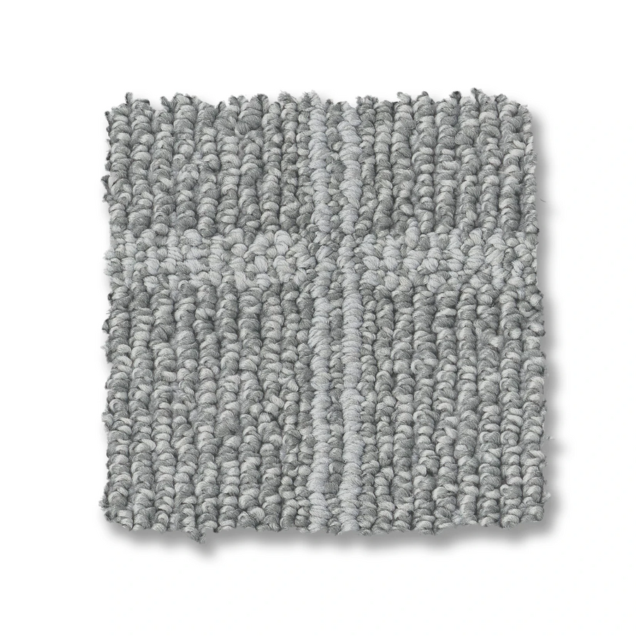 The Breeze Block Berber Carpet is a square, light gray swatch with textured fibers and a subtle, darker windowpane pattern running both horizontally and vertically.