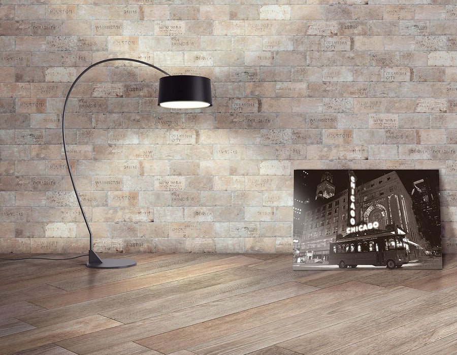 A lamp beside a picture sits on a table highlighted by Chicago 4x8 Brick Tile accents, bringing timeless charm to the space.