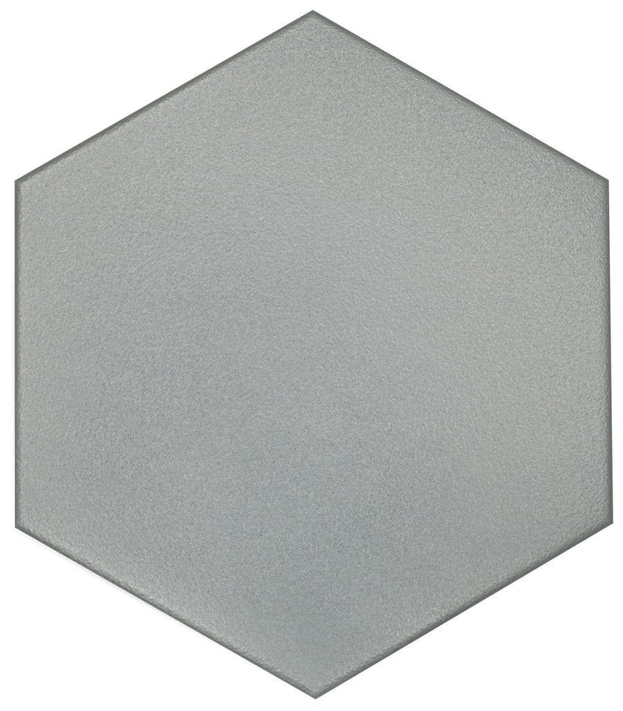 The Watercolor 8x9 Hexagon Matte Ceramic Tile features a flat, light gray, textured surface with sharp edges and geometric inspiration, shown against a white background.