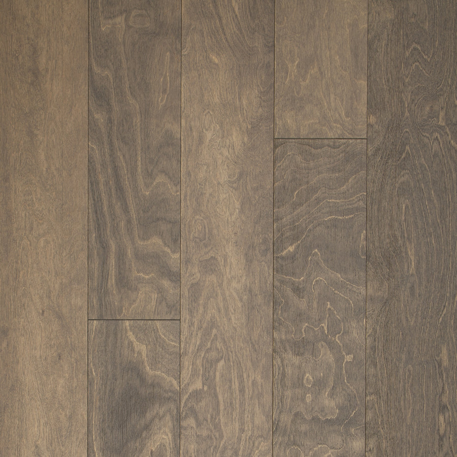 Close-up view of Canyon Creek Birch 6.5" Hardwood planks featuring a wire-brushed texture, natural wavy grain, and light to dark brown tones with a matte finish. Planks are shown laid side by side.