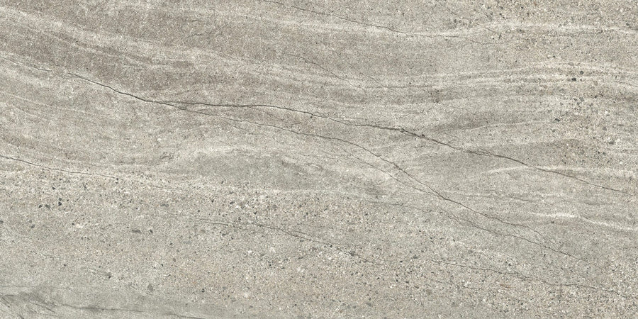A close-up of the Santorini 12x24 Porcelain Tile reveals a textured gray surface with subtle wavy patterns, fine natural cracks, and speckled gradations, capturing the tactile elegance and beauty of natural stone.