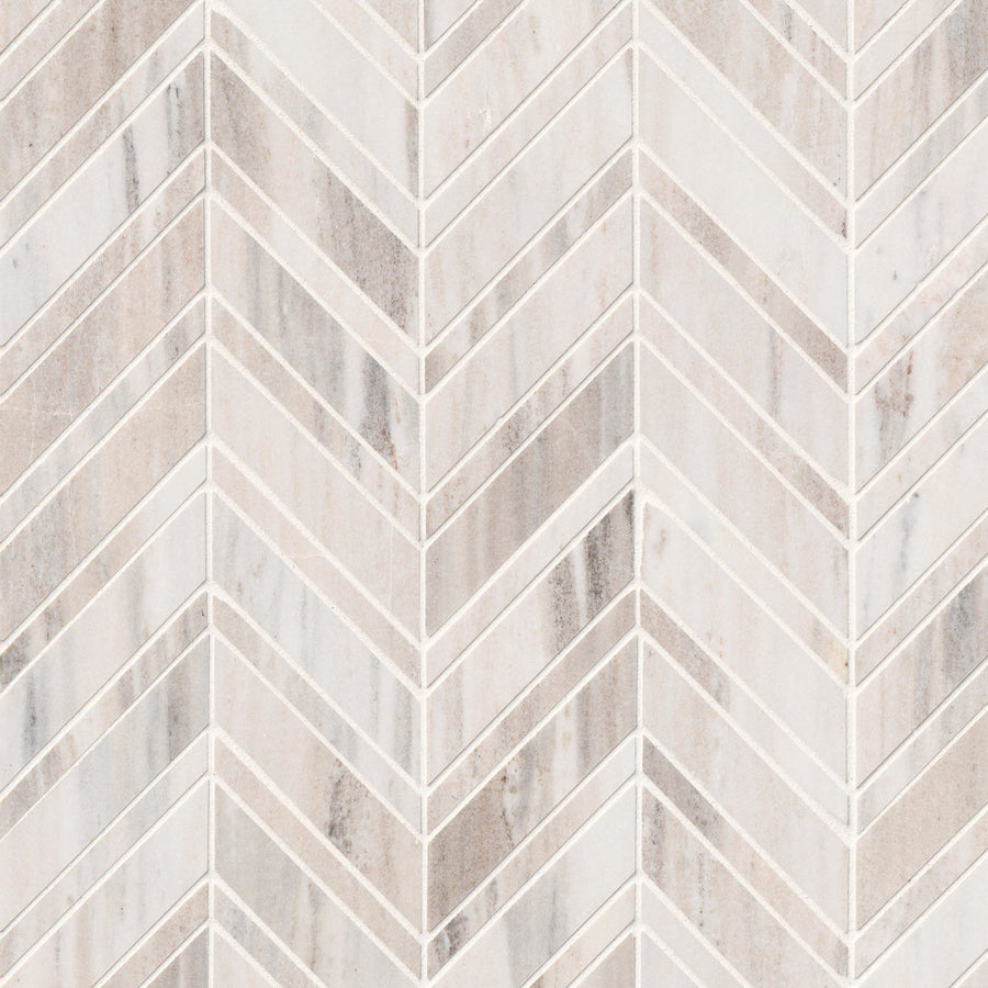 A close-up of Chevron Mosaic Natural Stone tiles arranged in a herringbone pattern, highlighting subtle beige and gray veining—an elegant option for backsplashes or natural stone tile accents.