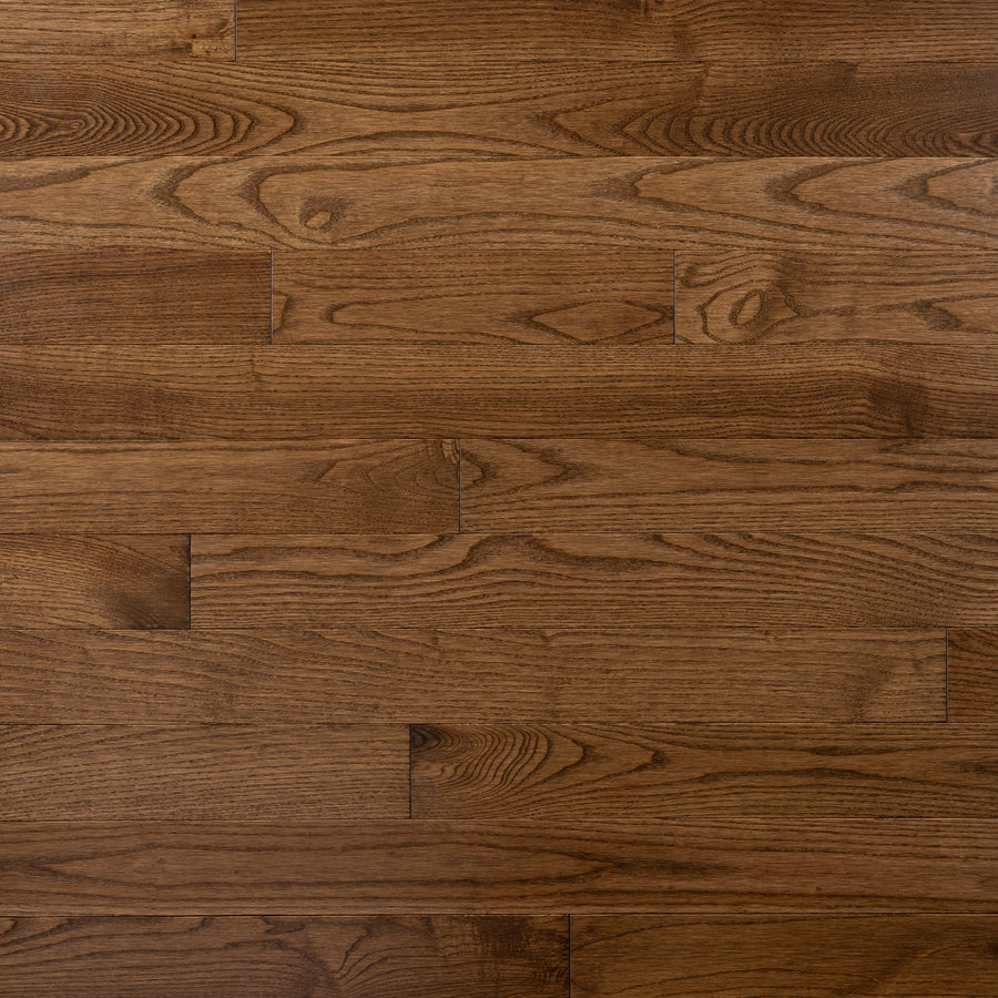 Westmont 3 1/4" Ash Hardwood features medium brown solid planks with visible grain and knots, offering a durable, smooth, and polished finish for a warm, natural look.