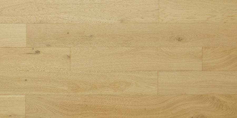 Dorchester White Oak 6 1/2" Hardwood offers light-colored, wide planks with visible grain and knots, arranged smoothly to showcase the wood’s natural texture.