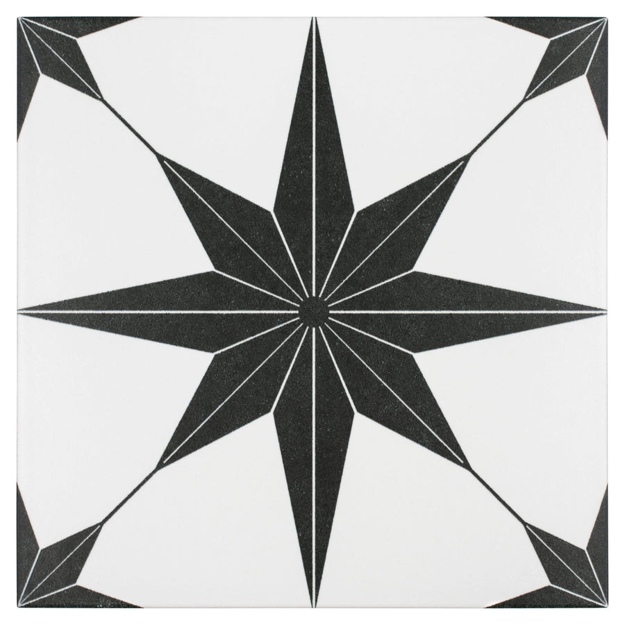 The Stella 9 3/4 x 9 3/4 Patterned Tile is a white tile showcasing a bold black eight-pointed starburst with thin radiating lines reaching toward each corner.