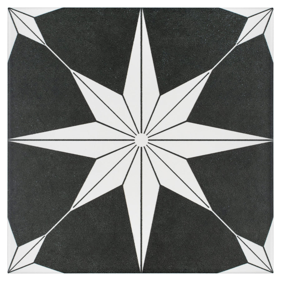 The Stella 9 3/4 x 9 3/4 Patterned Tile features a black and white eight-pointed starburst at the center, with geometric corners and radiating lines for a striking, modern design.
