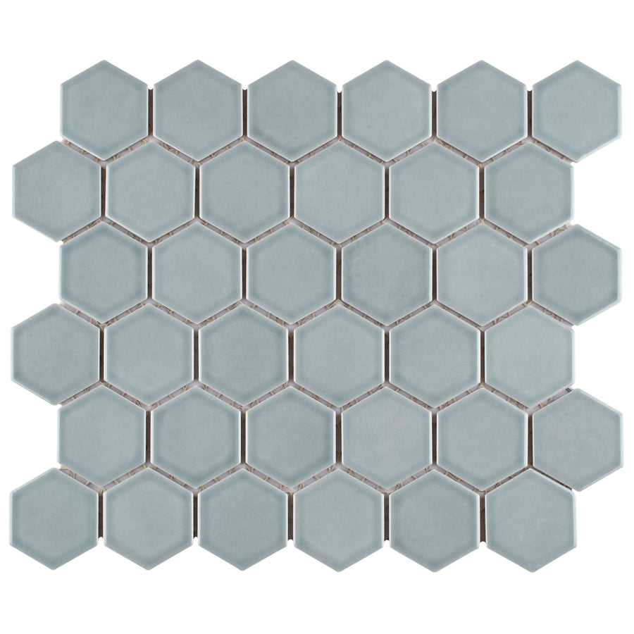 Tribeca 2" Hex Glossy Mosaic Tile features light gray porcelain hexagons on a mesh sheet, creating a sleek honeycomb pattern ideal for walls or floors with a modern geometric look.