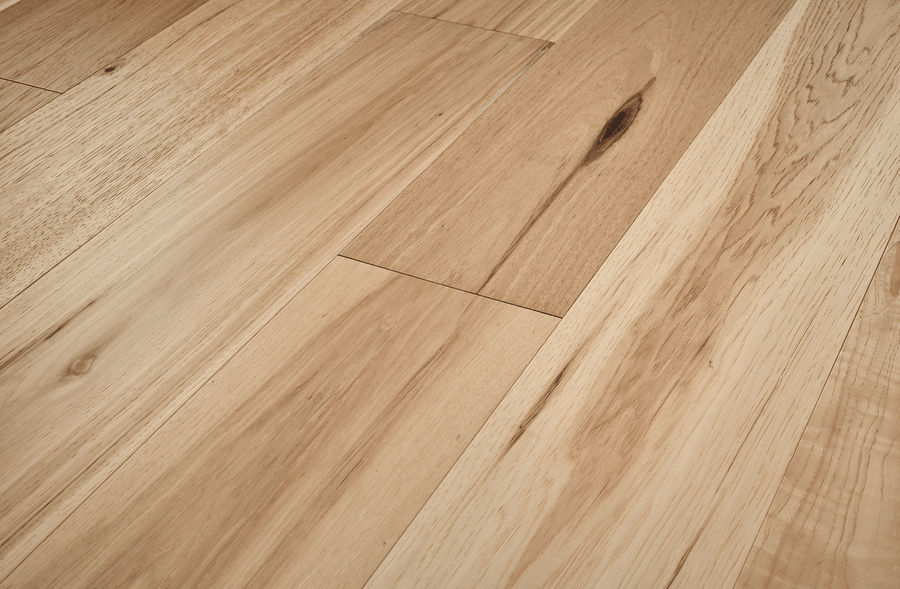 Close-up of Fairmount Hickory 7 1/2" Hardwood flooring, featuring natural grain patterns, knots, and a smooth, well-finished wide plank surface arranged seamlessly in a parallel layout.