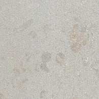 Close-up of the Platform 2x8 Porcelain Tile, showing a light gray, slightly textured surface with a metallic look, subtle irregular patterns, and faint beige and brownish spots scattered throughout.