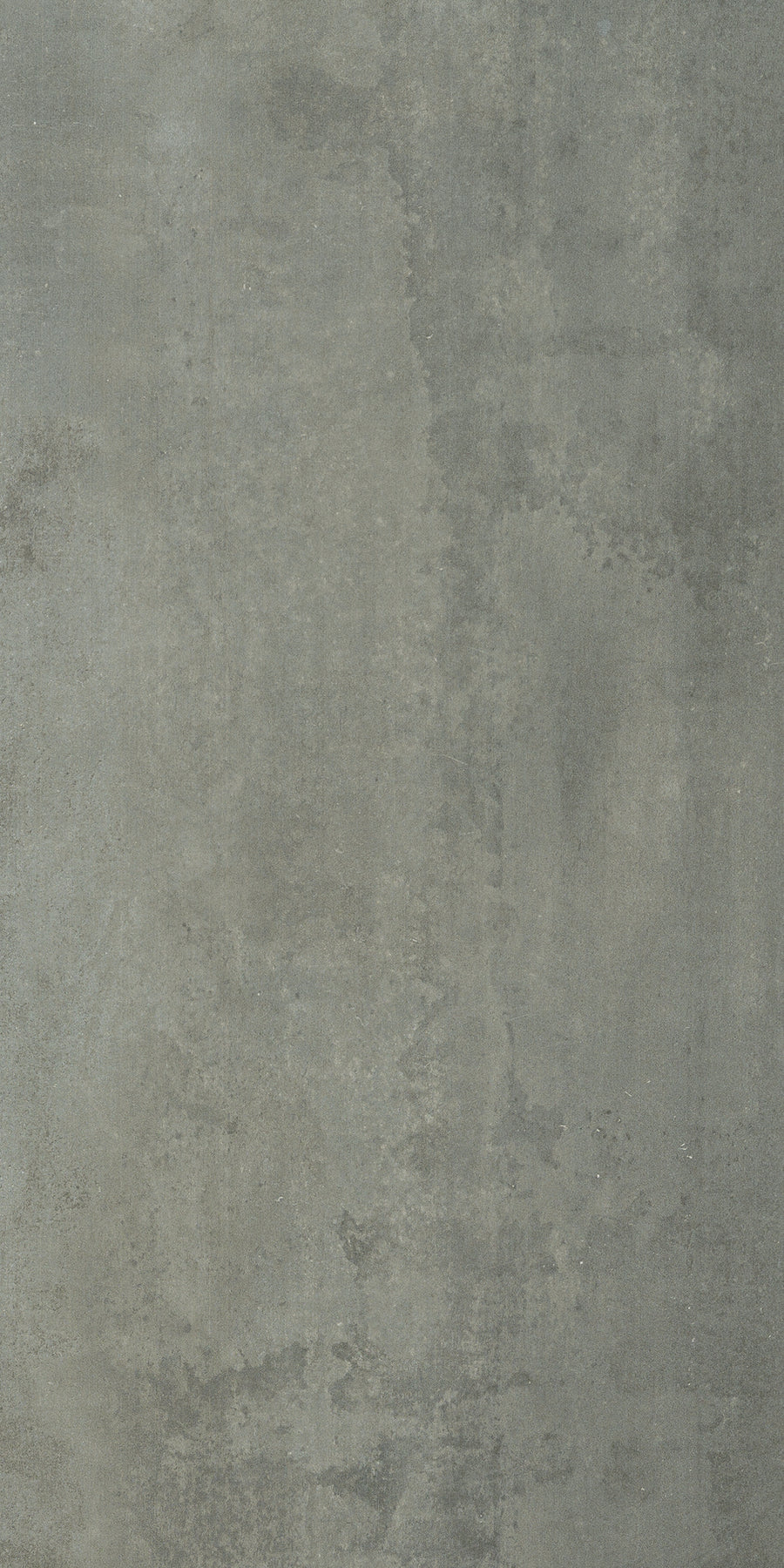 The Platform 12x24 Porcelain Tile features a textured gray surface with uneven coloring, subtle stains, and visible patches, delivering an industrial, weathered look inspired by aged metal plates and a muted metallic finish.