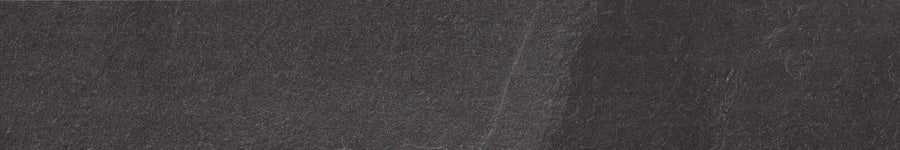 The Slide 8x48 Porcelain Tile features a textured black and dark gray surface with faint lines and subtle scratches, resembling modern slate and adding a contemporary touch to its gently worn look.