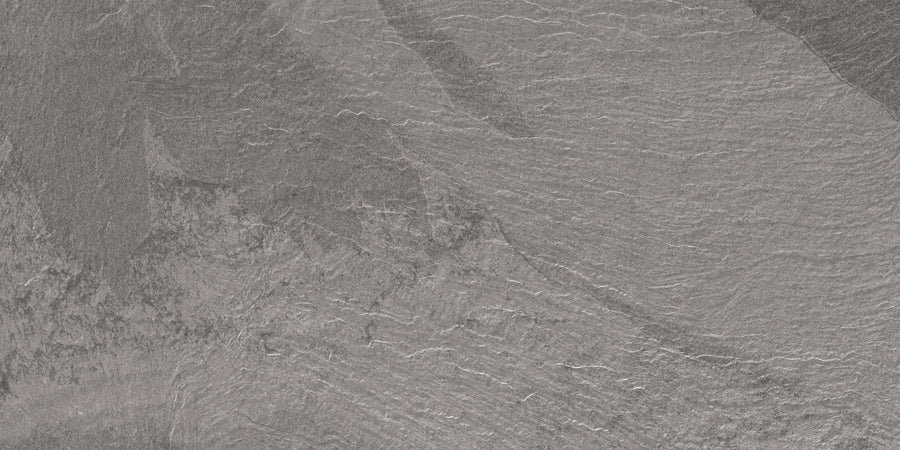 A close-up of the Slide 12x24 Porcelain Tile showcases its textured gray surface with natural lines, ridges, and layered patterns—ideal for modern slate-inspired and contemporary design applications.