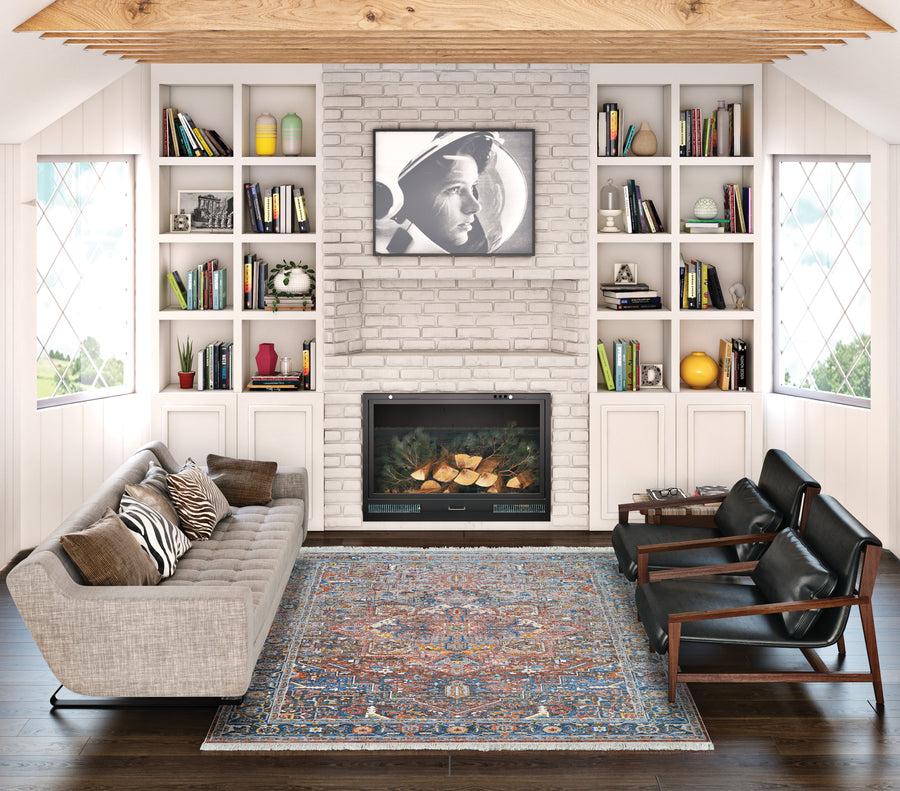A cozy living room features a gray sofa, two black armchairs, and the Halli Kerman Area Rug. Built-in bookshelves, a fireplace with a black-and-white photo above, wood beams, and large windows on both sides complete the charming space.