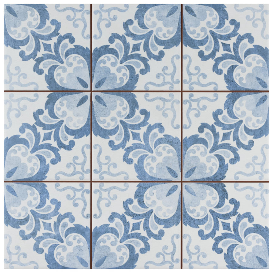 The Harmonia Floral Lattice 13x13 Patterned Tile features a symmetrical blue and white floral design with curved shapes and soft borders, creating a vintage look inspired by traditional encaustic tiles.