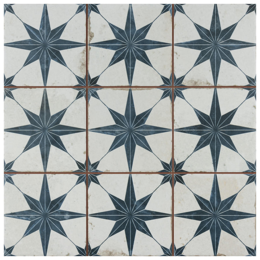 The Harmonia Kings Star 13x13 Patterned Tile features a dark blue eight-pointed star on a white background, with subtle wear for an encaustic-inspired, vintage industrial look. Suitable for both floor and wall applications.