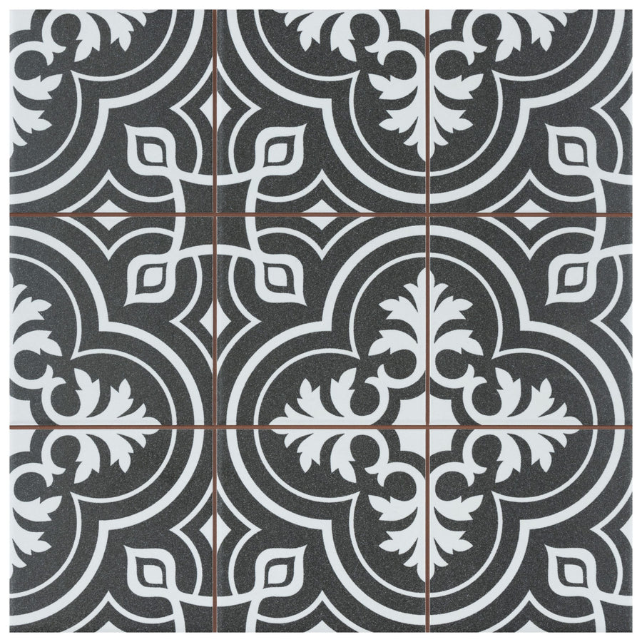 Four Harmonia Vintage 13x13 Patterned Tiles feature a black square base with an ornate white and gray symmetrical floral and geometric design, intersected by thin brown grout lines for a repeating decorative motif.