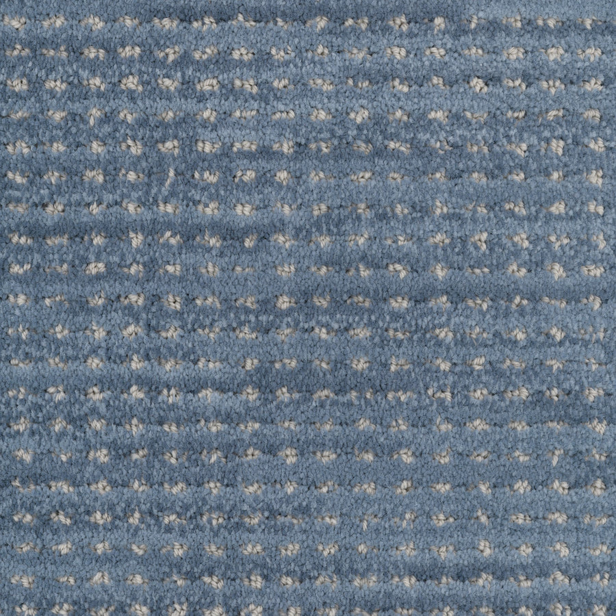 Close-up of Imagine Pet Friendly Carpet in blue, featuring a textured grid pattern with small raised white dots that highlight the handmade look and quality of solution dyed yarn.