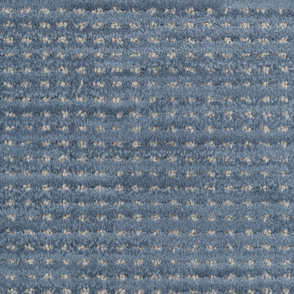 Close-up of Imagine Pet Friendly Carpet in blue, featuring a textured grid pattern with small raised white dots that highlight the handmade look and quality of solution dyed yarn.