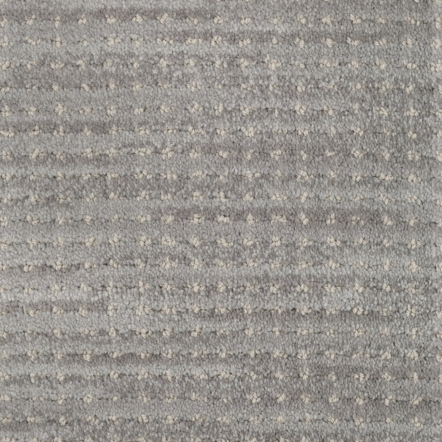 Close-up of Imagine Pet Friendly Carpet in textured gray wool, featuring a subtle pattern of small light dots and horizontal ridges. The soft, plush surface highlights handmade authenticity and pet-friendly design.