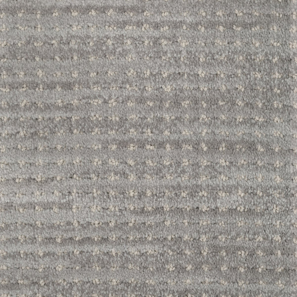Close-up of Imagine Pet Friendly Carpet in textured gray wool, featuring a subtle pattern of small light dots and horizontal ridges. The soft, plush surface highlights handmade authenticity and pet-friendly design.