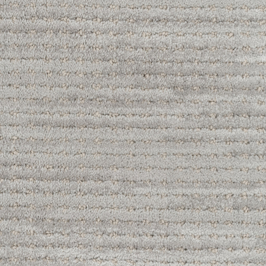 Close-up of Imagine Pet Friendly Carpet in light gray wool, showing a textured surface with subtle stripes and dotted accents. The soft, slightly raised fibers highlight the handmade authenticity throughout.