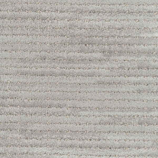Close-up of Imagine Pet Friendly Carpet in light gray wool, showing a textured surface with subtle stripes and dotted accents. The soft, slightly raised fibers highlight the handmade authenticity throughout.