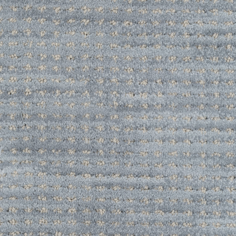 Close-up of Imagine Pet Friendly Carpet in textured blue wool, featuring a repeating pattern of small white dots. The soft, plush surface highlights its handmade appearance and quality craftsmanship.