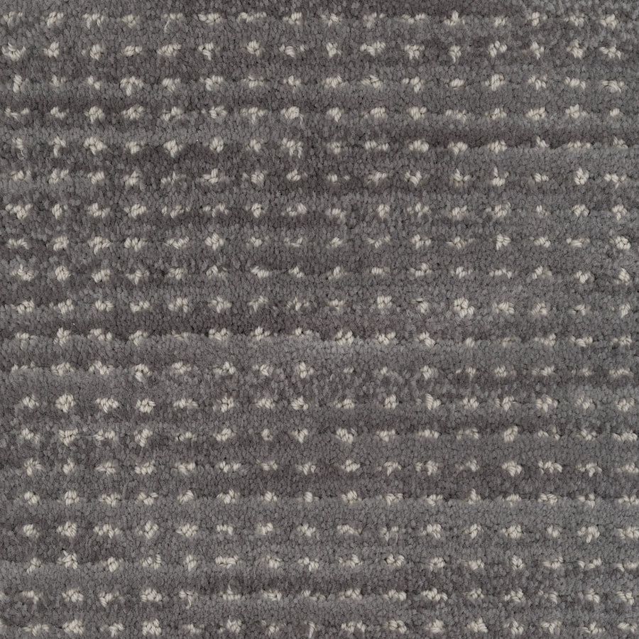 Close-up of Imagine Pet Friendly Carpet in textured gray wool with small, evenly spaced white dots and horizontal ridges. The soft, plush surface highlights its handmade authenticity and inviting feel.