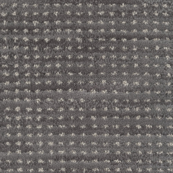Close-up of Imagine Pet Friendly Carpet in textured gray wool with small, evenly spaced white dots and horizontal ridges. The soft, plush surface highlights its handmade authenticity and inviting feel.