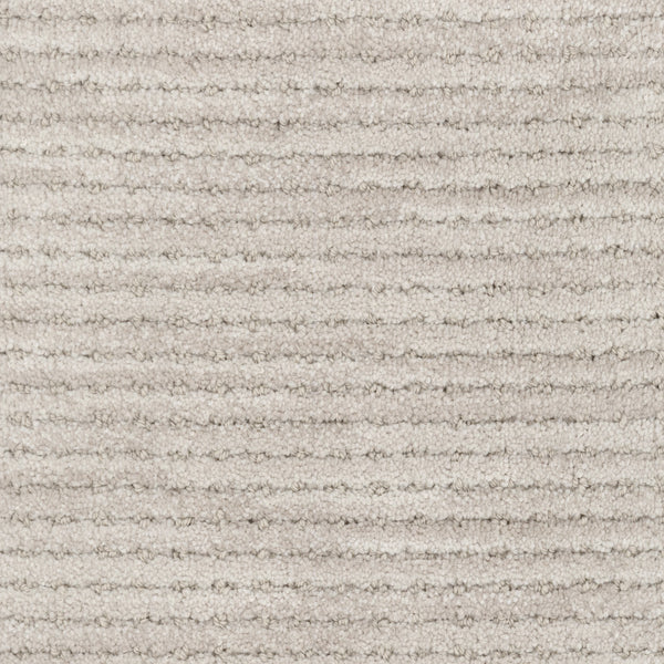 Close-up of Imagine Pet Friendly Carpet in light beige, showing textured wool with horizontal ribbed lines and a plush, soft surface. The uniform pattern emphasizes its handmade authenticity in every fiber.