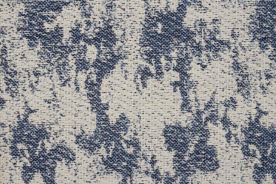 Close-up of the Jacquard Abstract On Trend Carpet shows an off-white background with blue ink-blot-like patterns. The flatwoven texture and visible weave give this custom carpet a slightly rough, textured look.