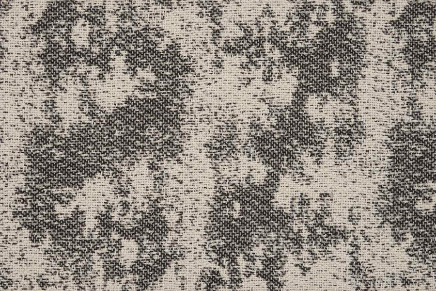 Close-up of the Jacquard Abstract On Trend Carpet, featuring a flatwoven texture with a mottled black and beige pattern and irregular, cloud-like patches inspired by abstract designs.