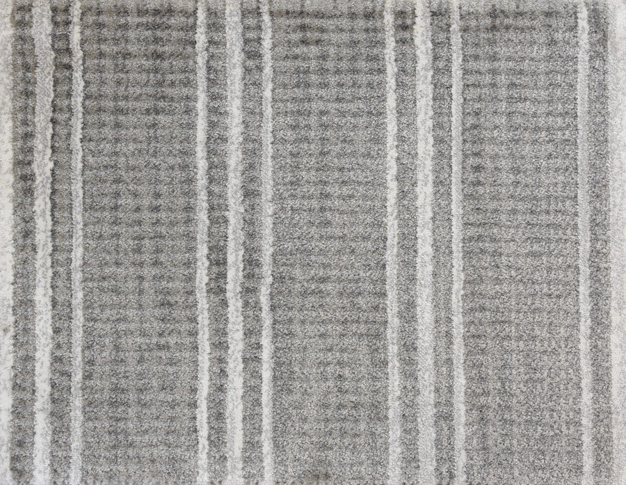 The Jazabella On Trend Carpet features a textured gray surface with a subtle plaid pattern, accented by white, slightly raised stripes for a modern look. This custom-finished rug is stain resistant, ensuring lasting style and easy maintenance.