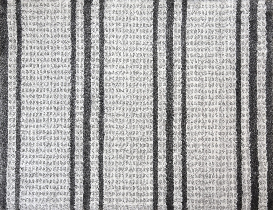 The Jazabella On Trend Carpet features soft, gray and white textured fabric with vertical black and dark gray stripes. Its stylish, slightly woven look is both stain resistant and modern—perfect for any space.