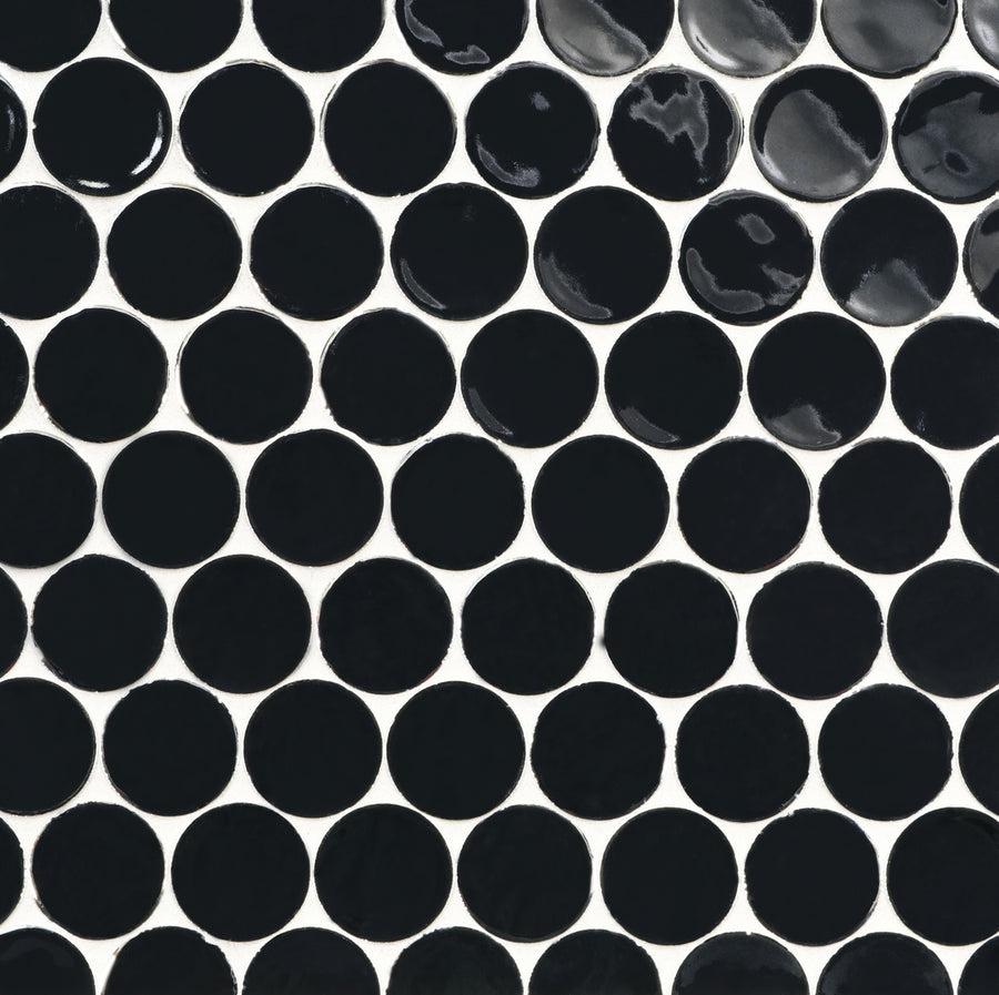 A close-up view of a tile surface featuring a repeating pattern of Ka-Nu Buoy 2" Pennyround Mosaic Tile in glossy black ceramic circles with white grout in between.