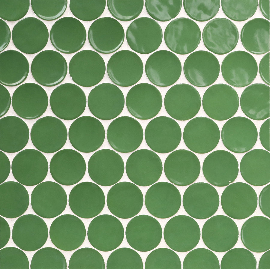 A close-up of a tiled surface featuring Ka-Nu Buoy 2" Pennyround Mosaic Tile—round, green ceramic pieces with white grout lines and a refined glaze.
