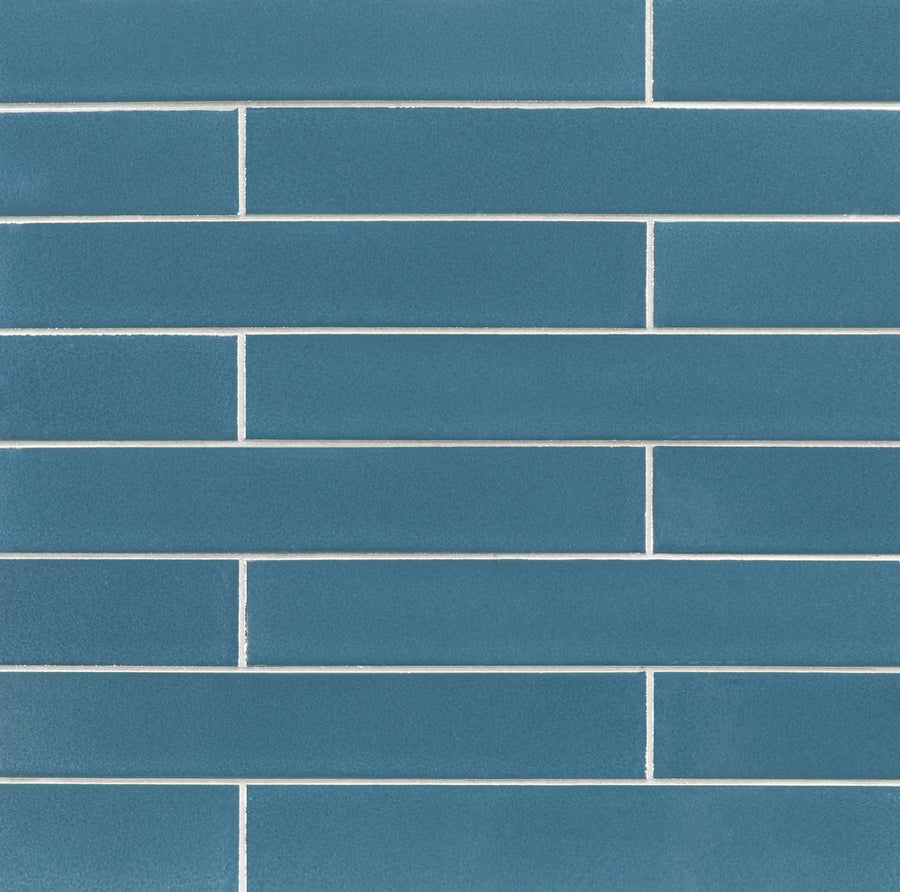 A close-up of a wall featuring Ka-Nu 1 5/8 x 9 1/2" Plank Ceramic Tiles in a vibrant, elongated rectangular shape, arranged horizontally in a staggered brick pattern with white grout lines.