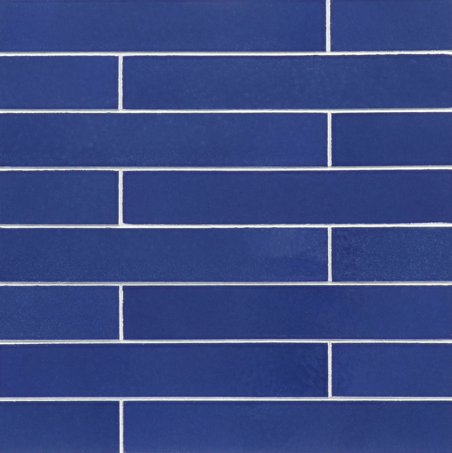 A wall adorned with Ka-Nu 1 5/8 x 9 1/2" Plank Ceramic Tile in vibrant blue, installed horizontally in a staggered brick pattern, featuring crisp white grout lines.