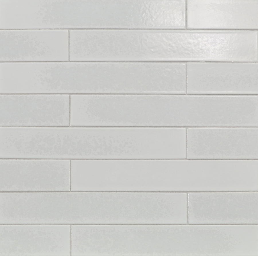 Ka-Nu 1 5/8 x 9 1/2" Plank Ceramic Tiles are installed on the wall in a horizontal, staggered brick pattern, showcasing their white color and smooth, slightly glossy ceramic surface.
