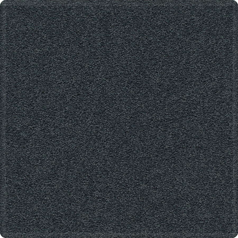A close-up of Dynamic Display Family Friendly Carpet shows its dark gray, textured surface—soft, dense, and slightly rounded at the corners—for easy-care durability that's perfect for any decorator.