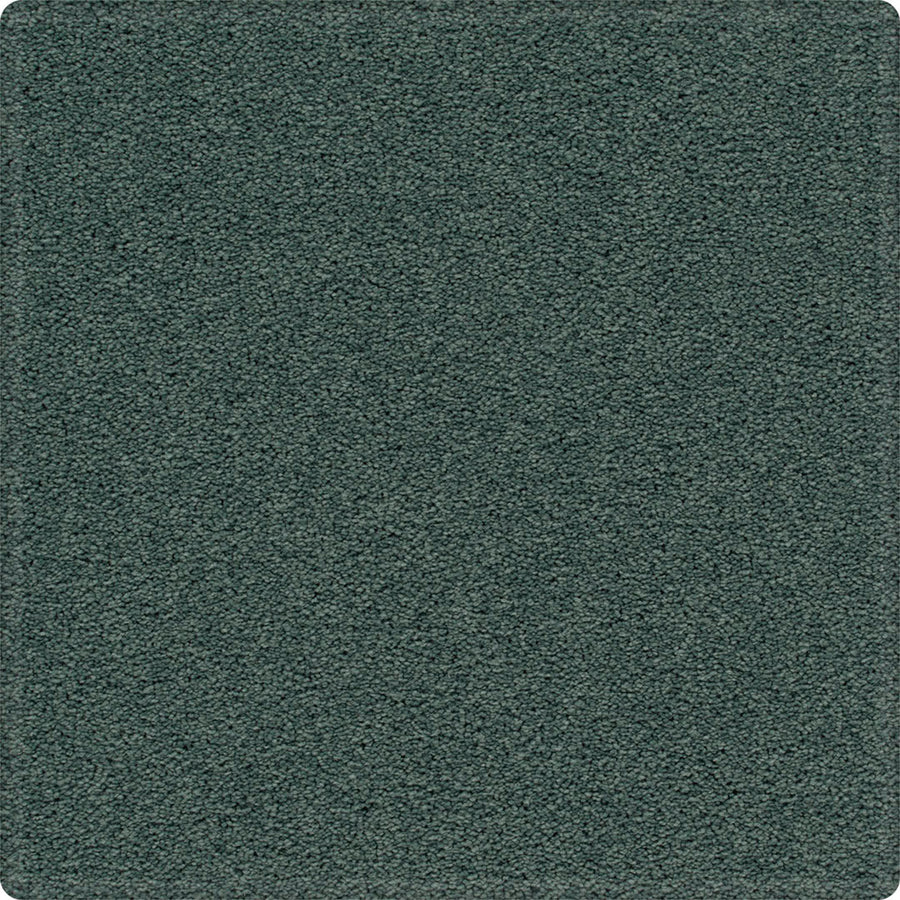 A close-up of the Dynamic Display Family Friendly Carpet shows its textured, dark green, soft surface and slightly rounded corners—offering easy-care durability that's perfect for home decorators.