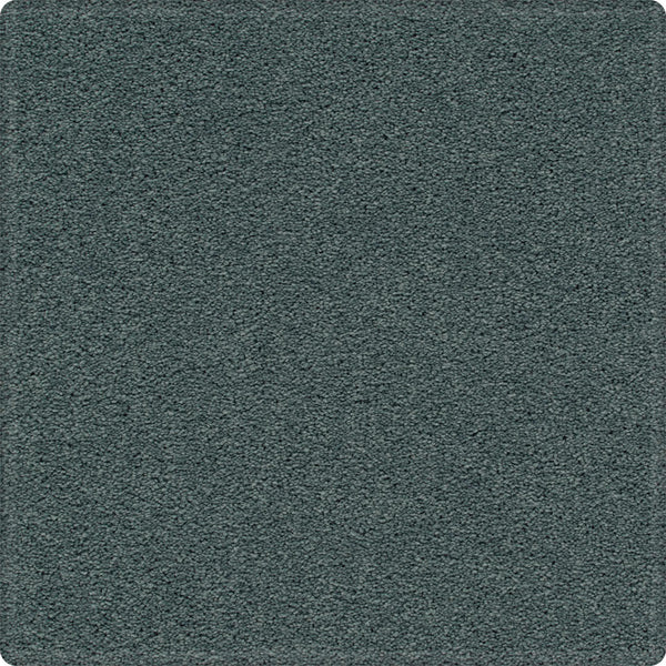 A close-up of the Dynamic Display Family Friendly Carpet shows its soft, even pile, rounded corners, and easy-care durability—making this textured dark teal carpet a decorator’s dream.