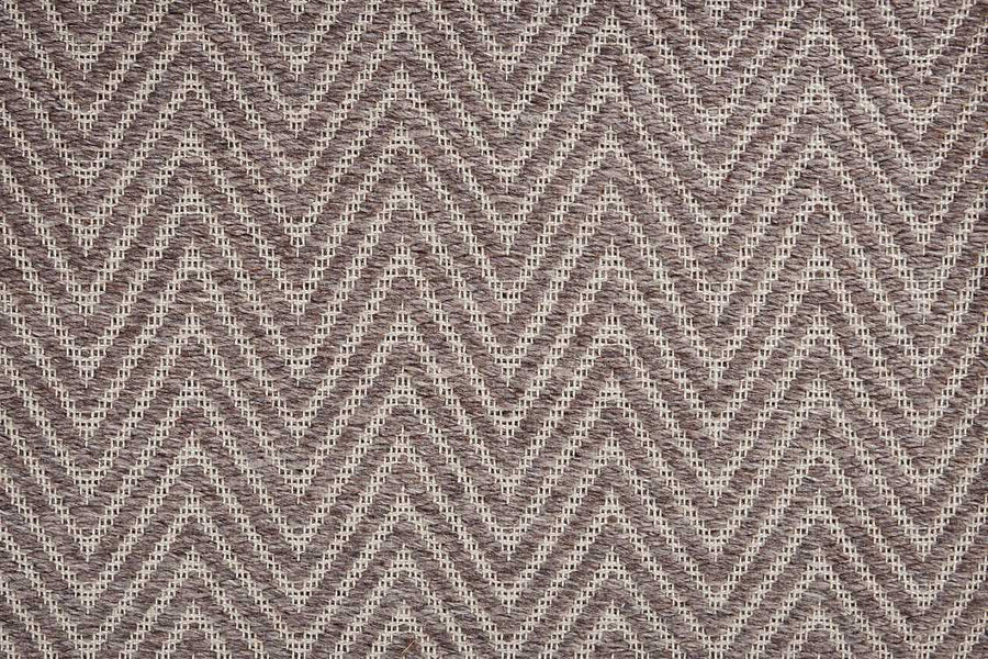A close-up of the Kauai On Trend Carpet shows its textured flatweave construction with a zigzag chevron pattern in beige and brown tones for a modern geometric look.