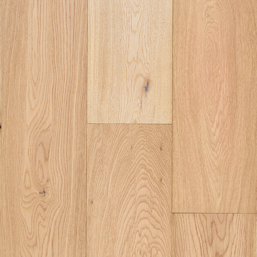 Close-up of Lexington Park 7 1/2" White Oak Hardwood flooring, showcasing light-toned boards with natural grain and knots in a staggered layout. The smooth matte finish enhances the wood's authentic character.